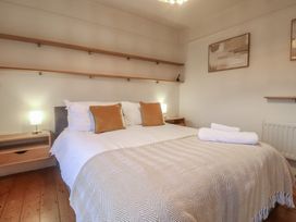 A bedroom with a bed and shelves at Devona in Beer