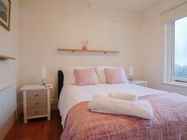 A bedroom with a bed and nightstand at Devona in Beer