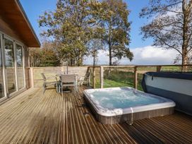 An outdoor area with a hot tub and seating at 20 Meadow Retreat in Dobwalls