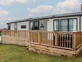 A cabin exterior with a deck and steps at Willow's Way in Stranraer