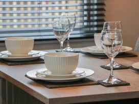 A dining table set with plates and glasses at Willow's Way in Stranraer