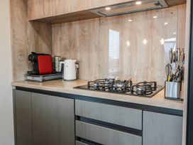 A kitchen with a gas stove and coffee machine at Willow's Way in Stranraer
