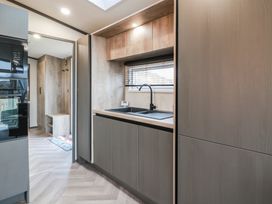 A kitchen with a sink and storage cabinets at Willow's Way in Stranraer
