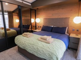 A bedroom with a bed and mirrored wardrobe at Willow's Way in Stranraer