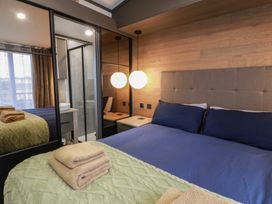 A bedroom with a bed and mirror at Willow's Way in Stranraer