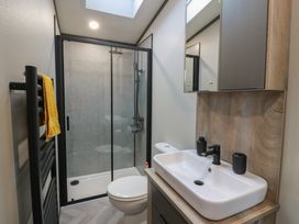 A bathroom with a shower, sink, and toilet at Willow's Way in Stranraer