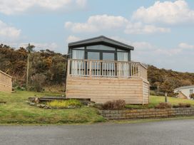 A cabin with decking and railing at Willow's Way in Stranraer
