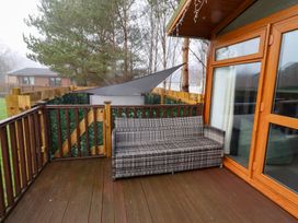 An outdoor space with a sofa and railing at Harper's Hideaway near Felmoor Holiday Park near Felton