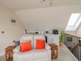 A living room with a sofa and kitchenette at Ard Uisce @ Estuary Bliss, Duncannon, County Wexford