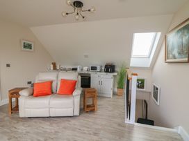 A living room with a sofa and kitchen appliances at Ard Uisce @ Estuary Bliss, Duncannon, County Wexford