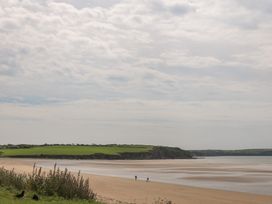 A beach with people walking near the water at Ard Uisce @ Estuary Bliss, Duncannon, County Wexford