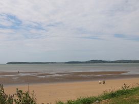 A beach with people walking along the shore at Ard Uisce @ Estuary Bliss, Duncannon, County Wexford