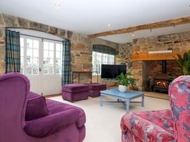 A living room with a sofa and television at The Mill House in Newton Abbot