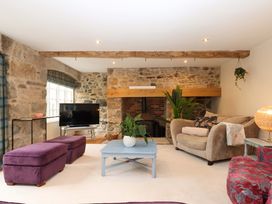 A living room with a sofa and television at The Mill House in Newton Abbot
