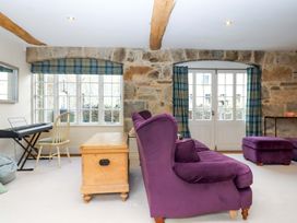 A living room with a keyboard and a sofa at The Mill House in Newton Abbot