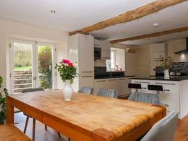 A kitchen with a wooden table and chairs at The Mill House in Newton Abbot