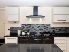 A kitchen with stove and sink at The Mill House in Newton Abbot