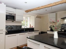 A kitchen with cabinets, a sink, and a stove at The Mill House in Newton Abbot