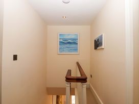 A hallway with wall art and a staircase at The Mill House in Newton Abbot
