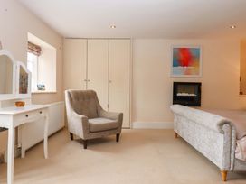 A bedroom with a chair and a fireplace at The Mill House in Newton Abbot