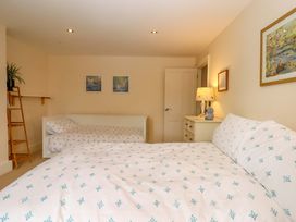 A bedroom with two beds and a bedside table at The Mill House in Newton Abbot