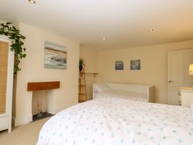 A bedroom with a bed and a shelf at The Mill House in Newton Abbot