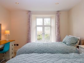 A bedroom with two beds and a desk at The Mill House in Newton Abbot