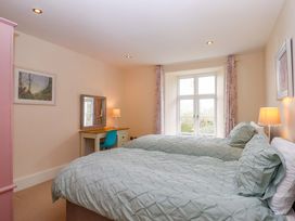 A bedroom with two beds and a desk at The Mill House in Newton Abbot