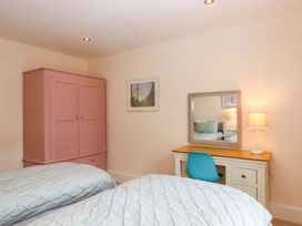 A bedroom with two beds and a desk at The Mill House in Newton Abbot