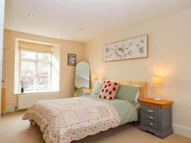 A bedroom with a bed and bedside table at The Mill House in Newton Abbot