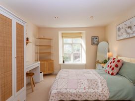 A bedroom with a bed and window at The Mill House in Newton Abbot
