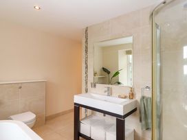 A bathroom with a sink, toilet, and shower at The Mill House in Newton Abbot