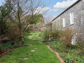A garden with a pathway and trees at The Mill House in Newton Abbot