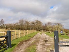 A gravel path leading through a field with a fence and gate at The Mill House in Newton Abbot