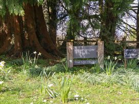 A sign for Halshanger Farm and The Mill House surrounded by grass and flowers at The Mill House in Newton Abbot