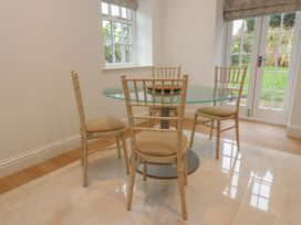 A dining room with a glass table and four chairs at The Lodge House in Dolphinholme near Galgate