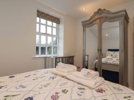 A bedroom with a bed and wardrobe at The Lodge House in Dolphinholme near Galgate