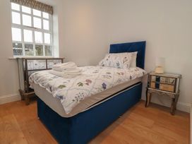 A bedroom with a single bed and bedside table at The Lodge House in Dolphinholme near Galgate