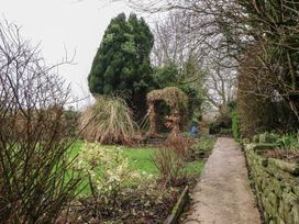 A garden with a walkway and various vegetation at The Lodge House in Dolphinholme near Galgate