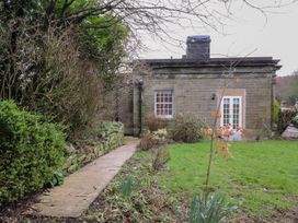 An exterior view of a house with a pathway surrounded by plants at The Lodge House in Dolphinholme near Galgate