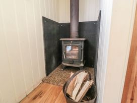A wood stove with firewood next to it at Honeysuckle Hut, Potto Grange Farm Northallerton