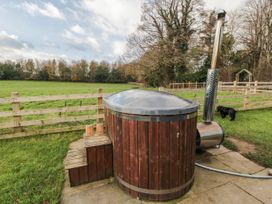 A hot tub with a smoke stack in a yard at Honeysuckle Hut, Potto Grange Farm, Northallerton