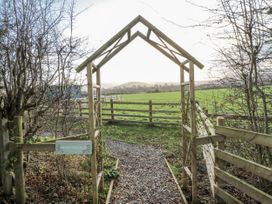 A pathway leading through a gateway labeled Honeysuckle at Honeysuckle Hut, Potto Grange Farm, Northallerton
