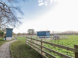 A blue cabin and pathway in a field at Honeysuckle Hut, Potto Grange Farm Northallerton