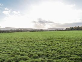 A field with grass and hills in the background at Honeysuckle Hut, Potto Grange Farm Northallerton