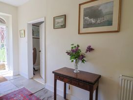 A hallway with a table and vase of flowers at Goulds Farmhouse, Milborne St Andrew