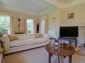 A living room with a sofa and television at Goulds Farmhouse in Milborne St Andrew