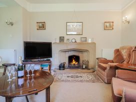 A living room with a fireplace and television at Goulds Farmhouse in Milborne St Andrew