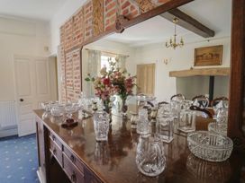 A dining room with a sideboard and mirror at Goulds Farmhouse in Milborne St Andrew