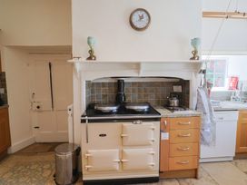 A kitchen featuring an AGA cooker, sink, and dishwasher at Goulds Farmhouse in Milborne St Andrew